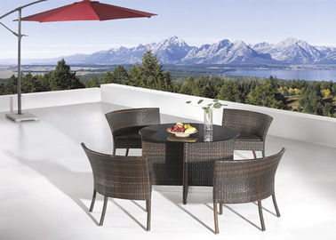 A mobília do jardim do Rattan de 4 Seater ajusta-se em volta da mesa de jantar e das cadeiras de vidro
